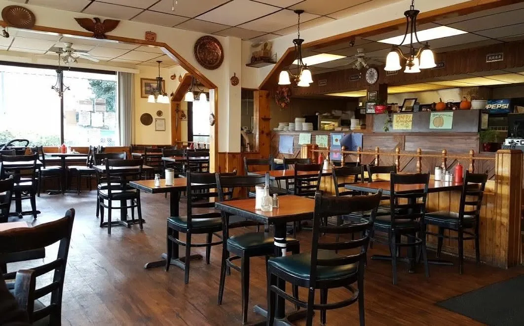 The dining room, with wood panelling, pendant lights and dark wooden chairs