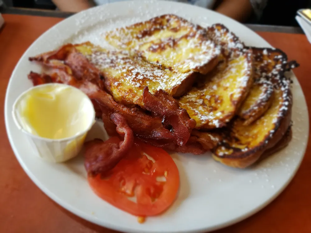 French toast with bacon and a sliced tomato
