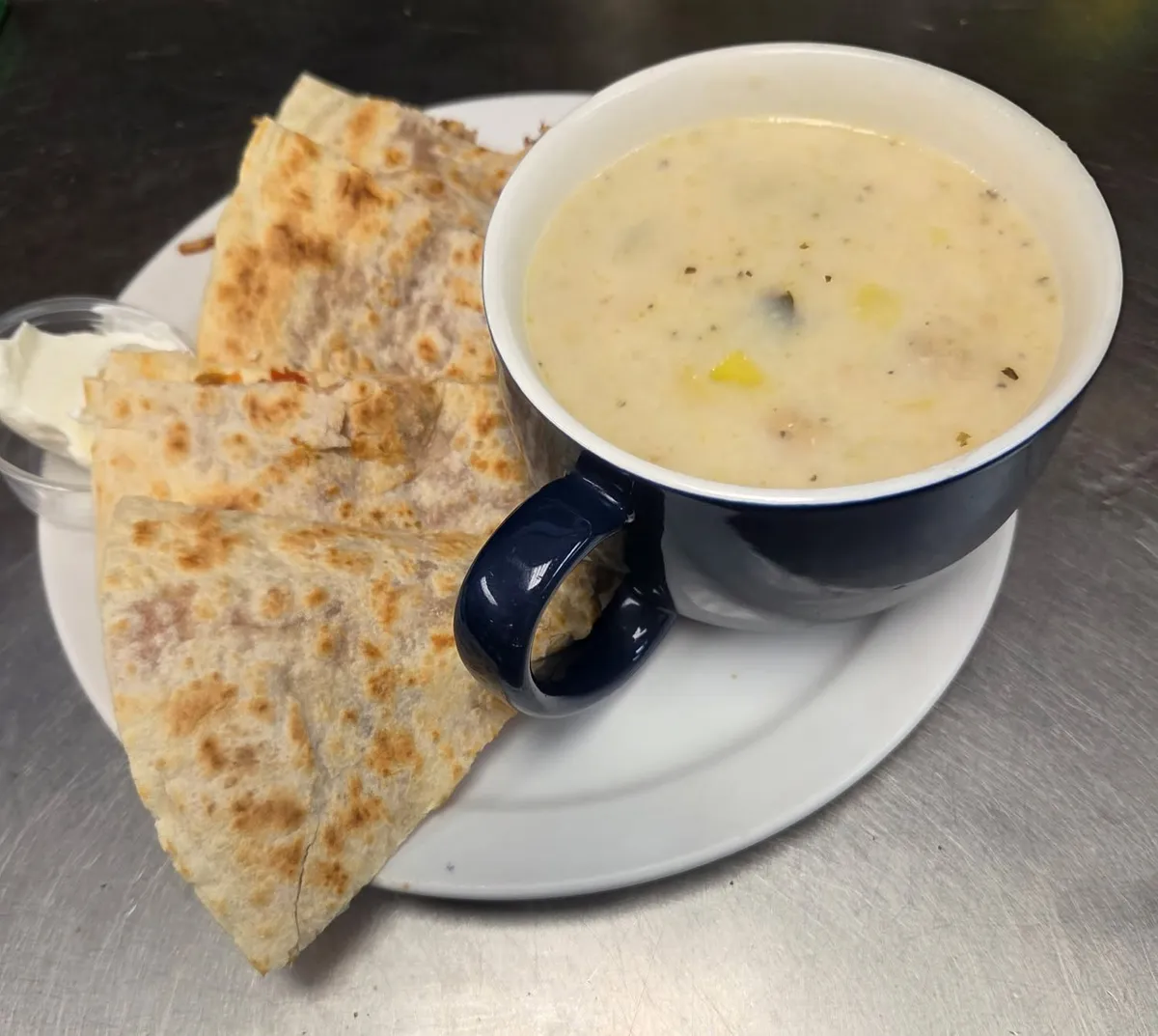 Quesadilla with sour cream and a cup of creamy soup