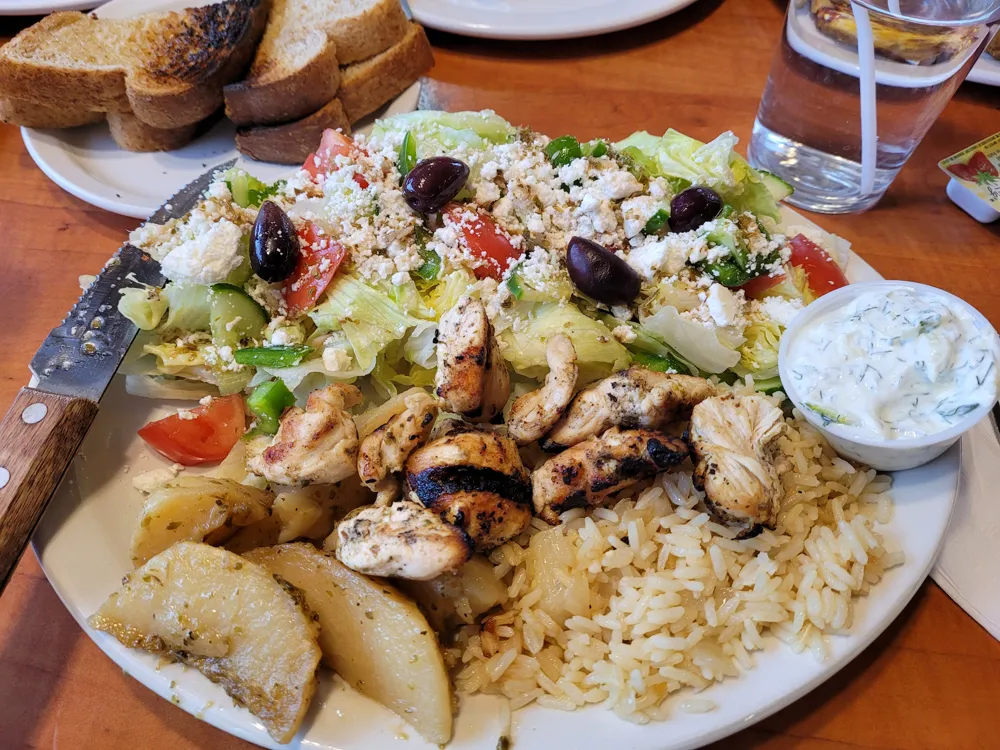 Souvlaki with rice, lemon potatoes, Greek salad and tzatziki